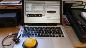 A Mac laptop with a bigh yellow switch connected